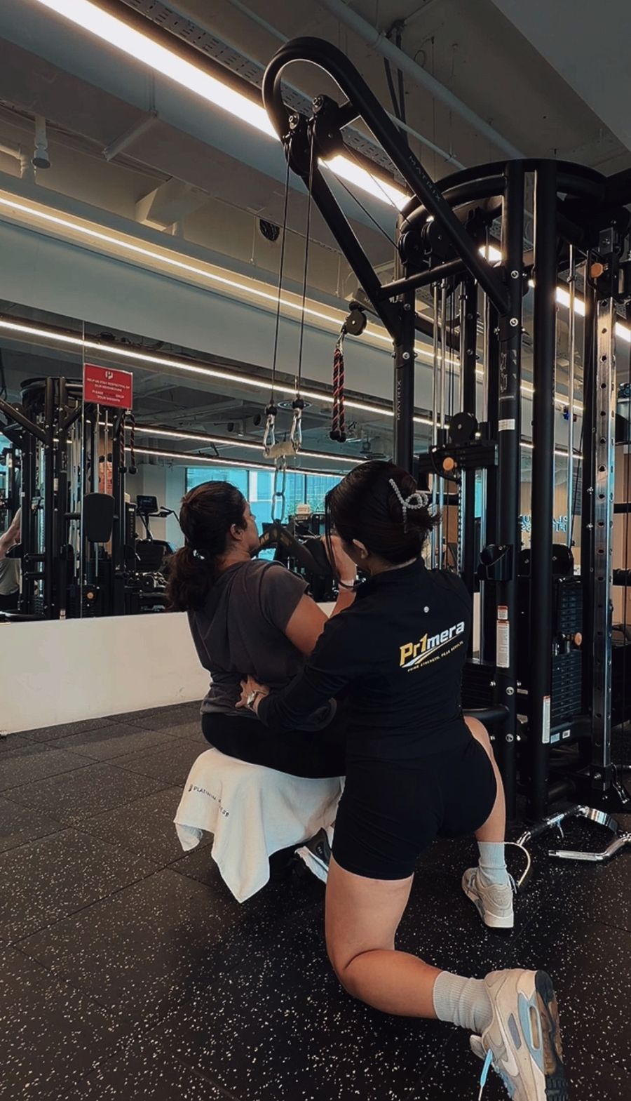 Patricia cueing a client's position during a seated cable pull.