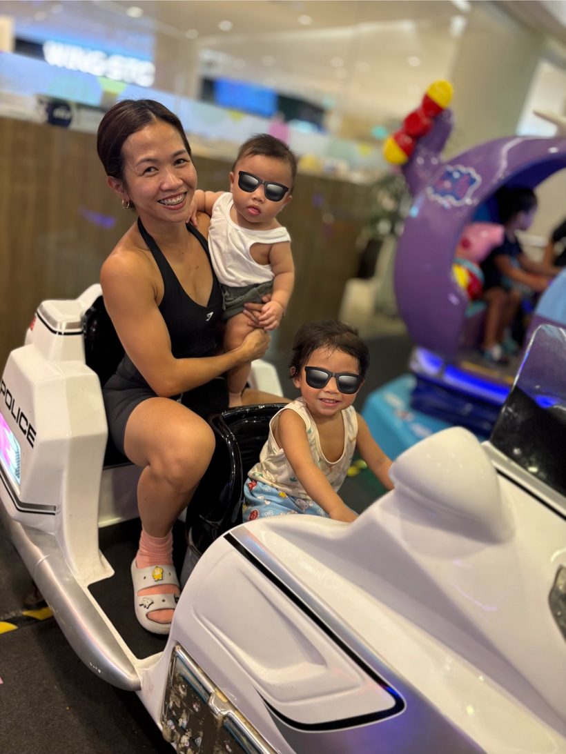 Patricia with her two young children at an indoor play area.