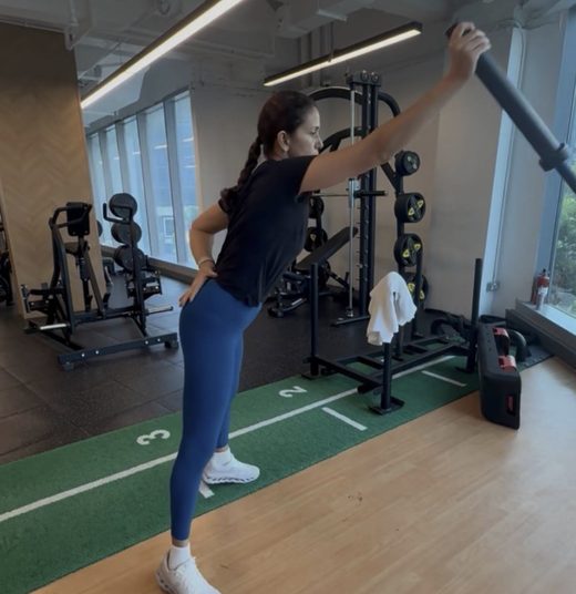 himani T Dahiya performing an overhead barbell movement in the studio.